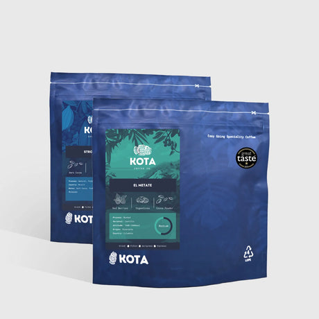 Two blue KOTA coffee packages on a light gray background